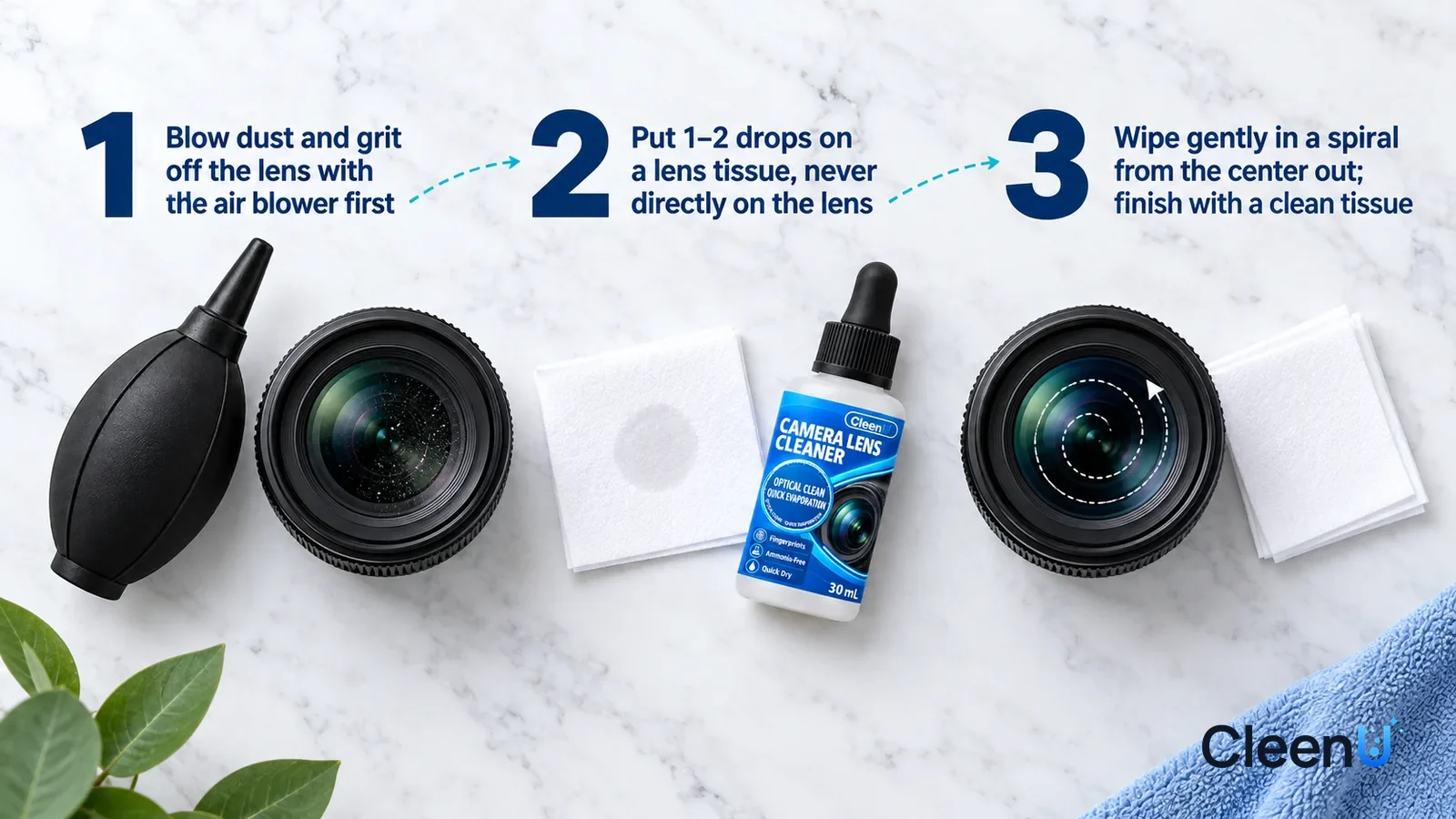 Illustration: CleenU Camera Lens Cleaner — an overhead shot straight down onto a light marble tabletop, no hands: (1) a black rubber air blower and a camera lens (unbranded